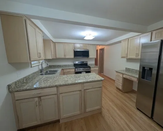 a kitchen with stainless steel appliances granite countertop a sink stove and refrigerator