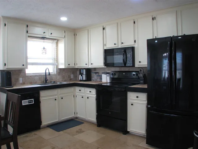 a kitchen with granite countertop a refrigerator and a sink