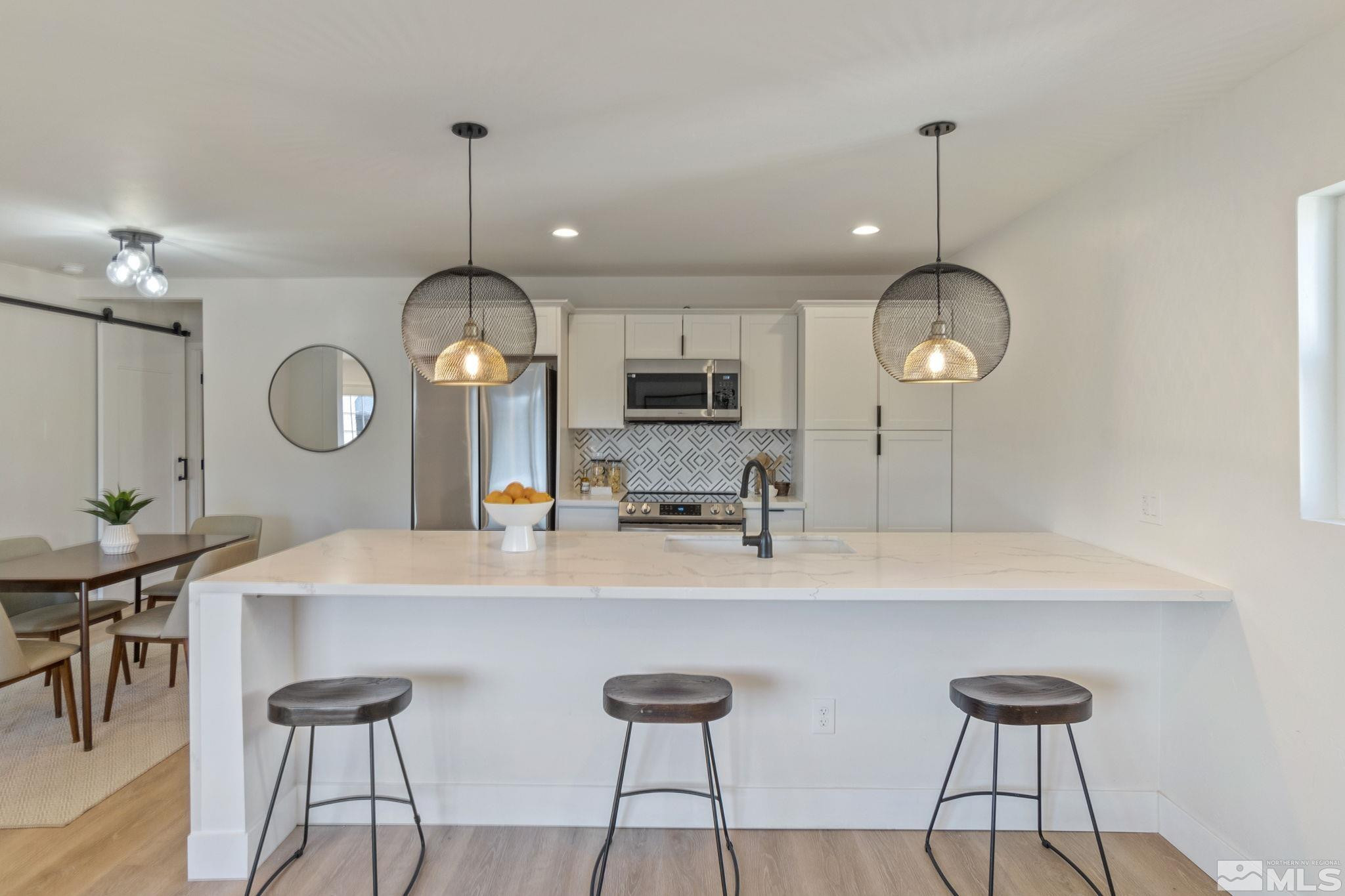 711 Balzar Circle Reno, NV 89502 - Photo 4 of 35 a kitchen with stainless steel appliances a kitchen island a stove a table and chairs in it
