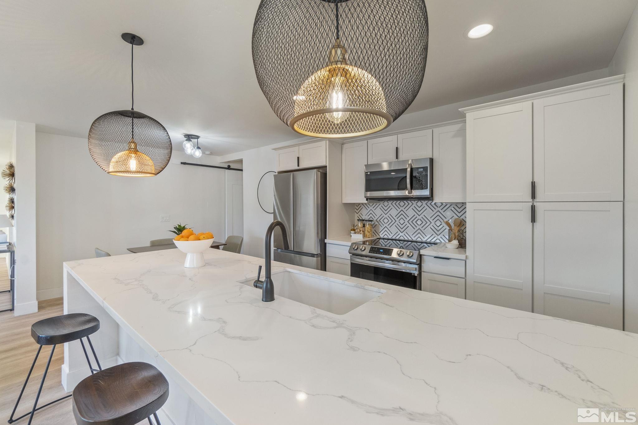 711 Balzar Circle Reno, NV 89502 - Photo 6 of 35 a kitchen with stainless steel appliances granite countertop a sink a stove and a wooden floors