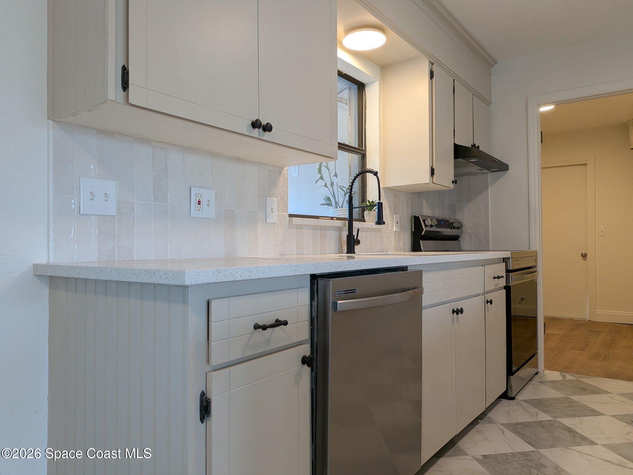 999 Cardon Drive Rockledge, FL 32955 - Photo 2 of 8 a kitchen with cabinets appliances a sink and a counter top space