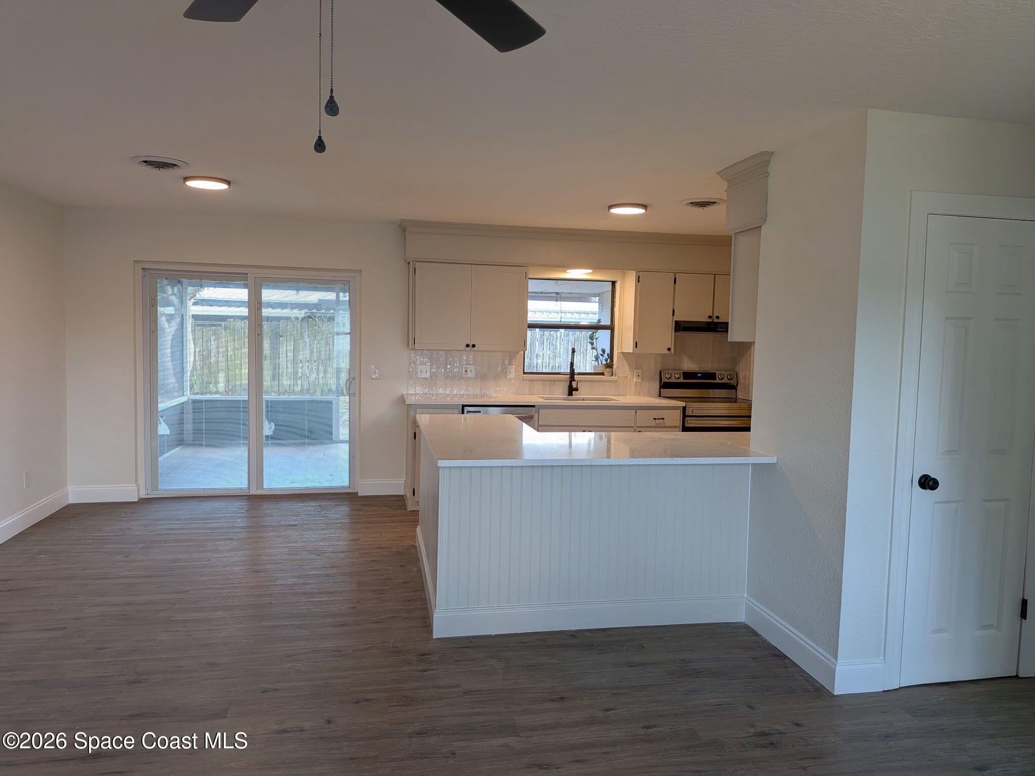 999 Cardon Drive Rockledge, FL 32955 - Photo 4 of 8 a large kitchen with hardwood floor and a sink