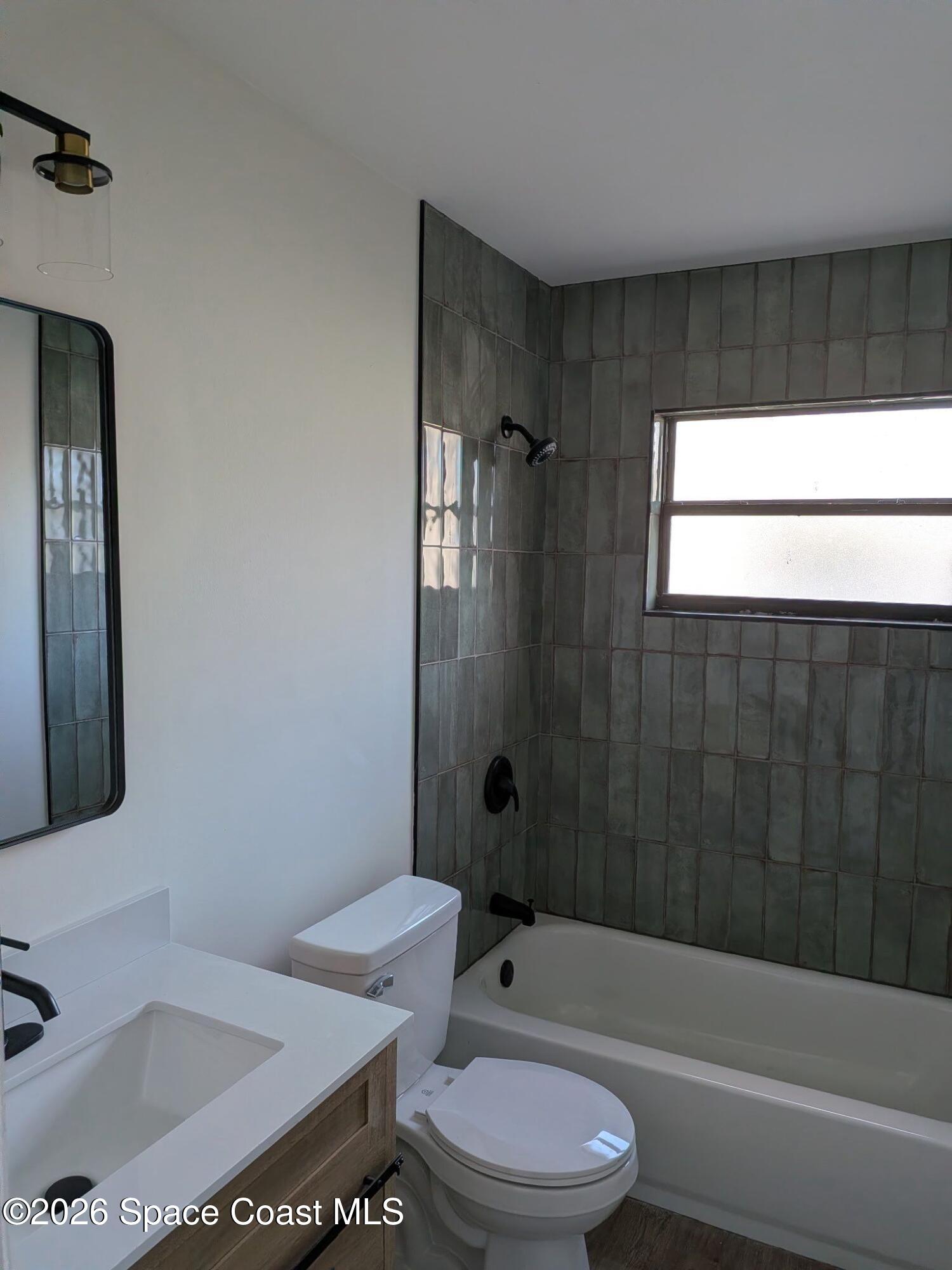 999 Cardon Drive Rockledge, FL 32955 - Photo 7 of 8 a bathroom with a toilet a sink and bathtub