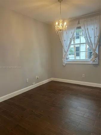 a view of wooden floor and a chandelier in a room