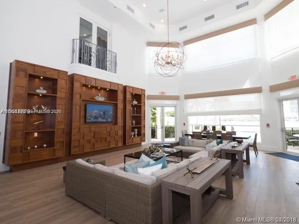 a living room with furniture a chandelier and a dining table