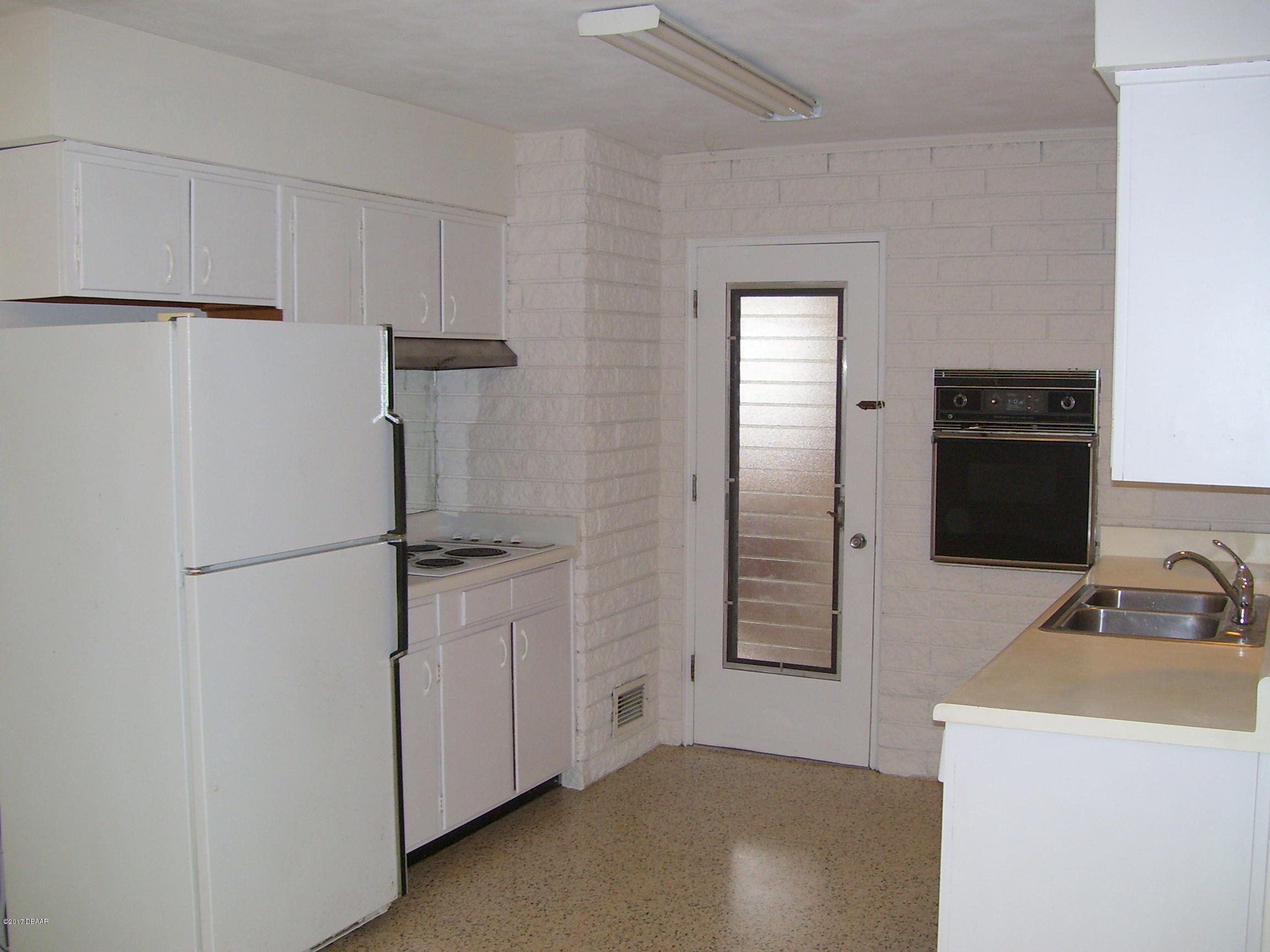 61 Rivocean Drive Ormond Beach, FL 32176 - Photo 10 of 23 a kitchen with a refrigerator and cabinets
