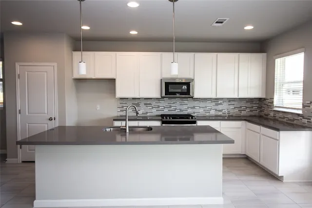 a kitchen with stainless steel appliances granite countertop a sink stove and cabinets