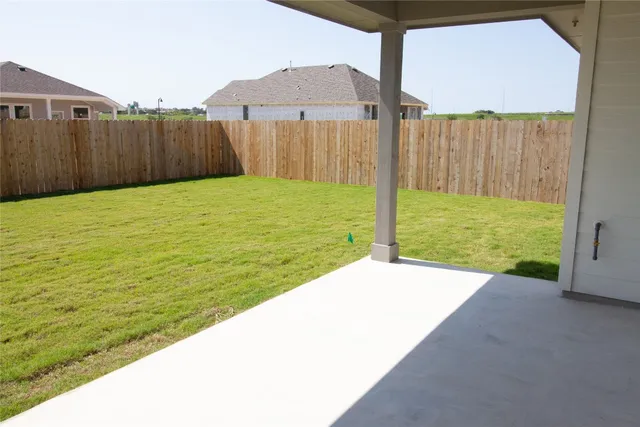 a view of a backyard with wooden fence