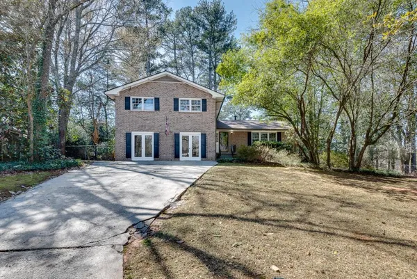 a front view of a house with yard and trees