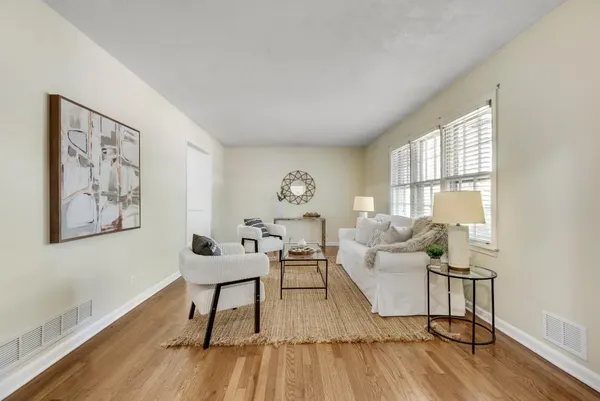 a living room with furniture and a wooden floor