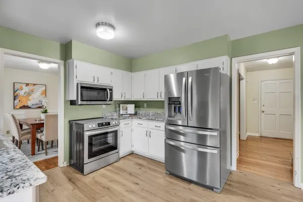 a kitchen with granite countertop a stove a sink and a refrigerator