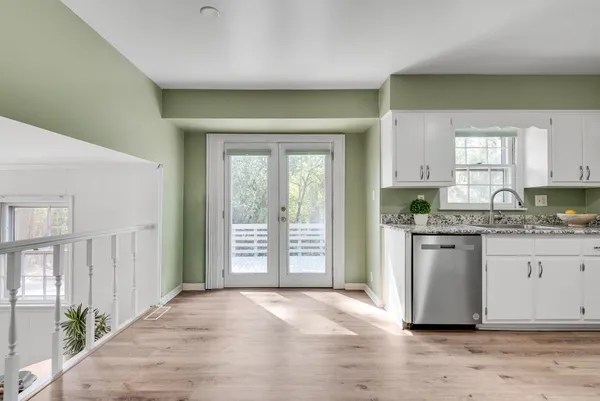 a view of a livingroom with furniture hardwood floor and windows