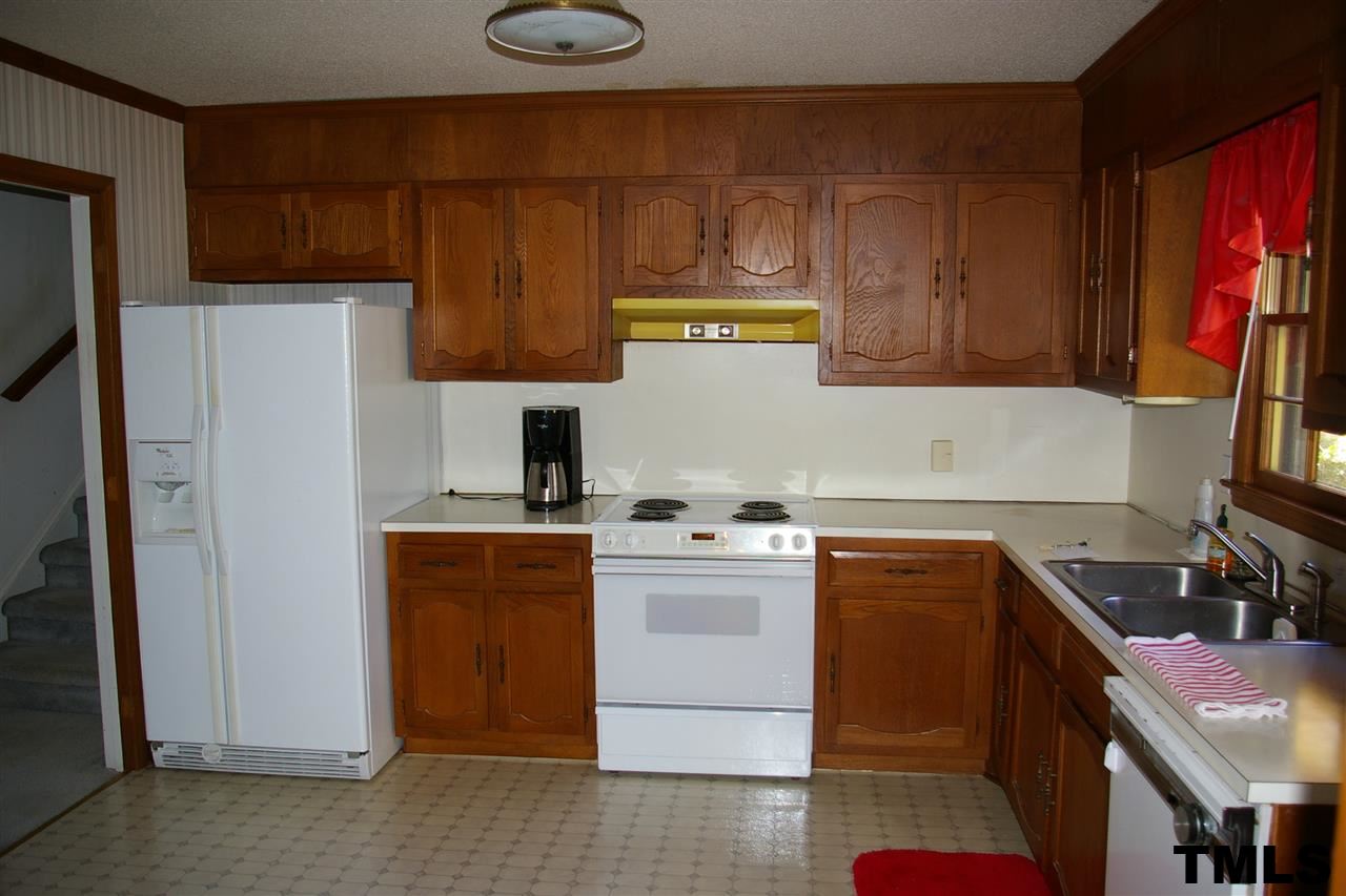 2609 Wycliff Road Raleigh, NC 27607 - Photo 4 of 14 a kitchen with stainless steel appliances a stove a refrigerator a sink and wooden cabinets