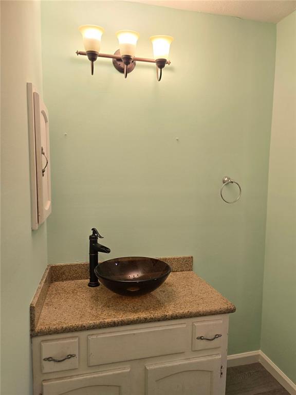 6992 Ivy Pointe Row Austell, GA 30168 - Photo 26 of 32 a bathroom with a granite countertop sink and vanity