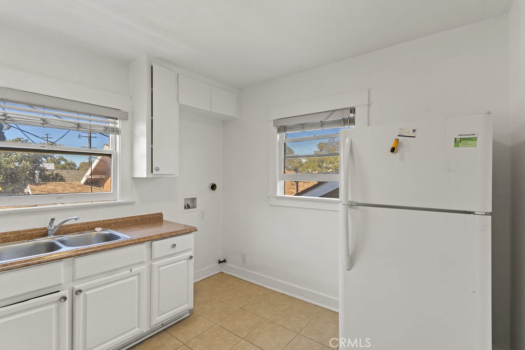224 West 14th Street Long Beach, CA 90813 - Photo 18 of 31 a white refrigerator freezer sitting inside of a kitchen