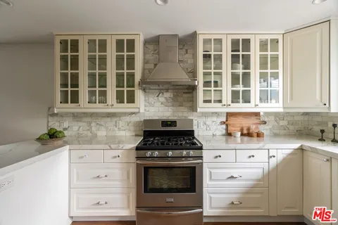 a kitchen with white cabinets and refrigerator