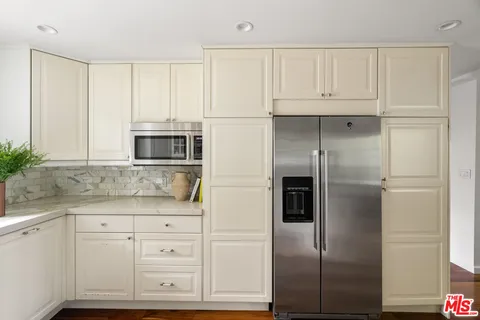 a kitchen with kitchen island a counter top space a sink stainless steel appliances and cabinets