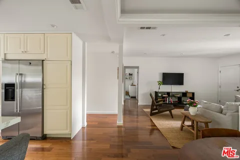 a spacious bedroom with a bed a chandelier and a window