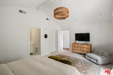 a bedroom with a bed and a flat screen tv