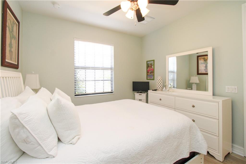 9159 Delano Street, Unit 9905 Naples, FL 34113 - Photo 21 of 44 a spacious bedroom with a bed and a large mirror