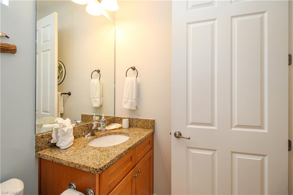 9159 Delano Street, Unit 9905 Naples, FL 34113 - Photo 22 of 44 a bathroom with a granite countertop sink and a mirror