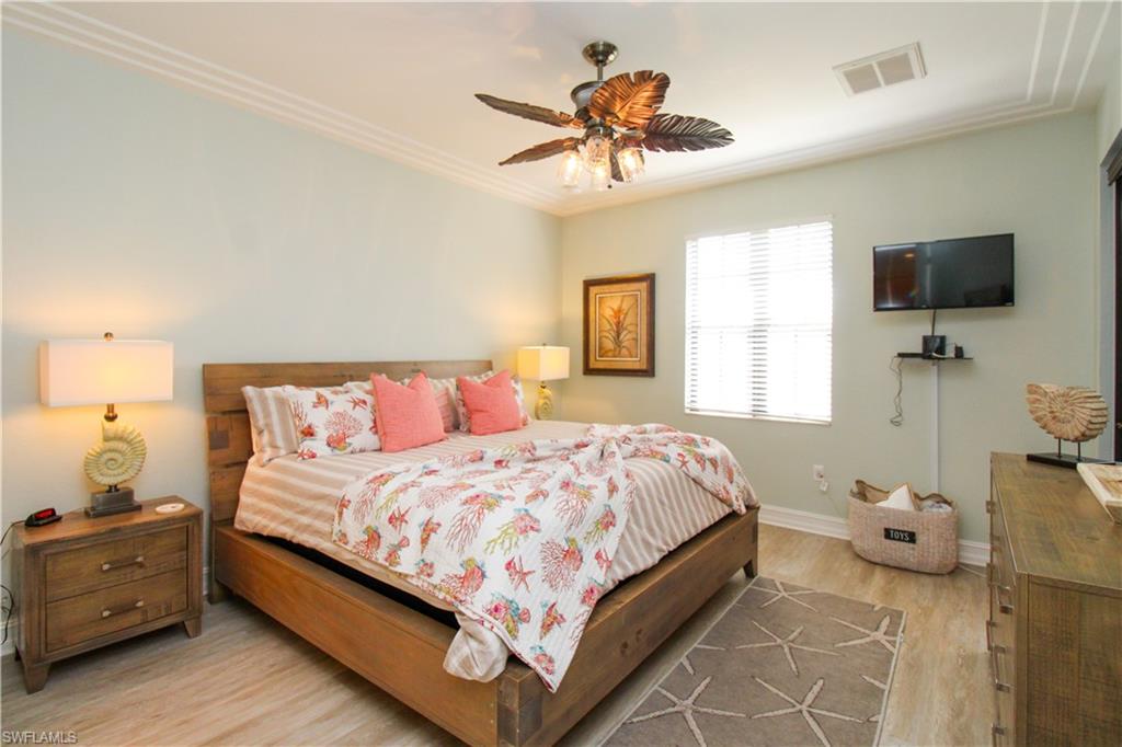 9159 Delano Street, Unit 9905 Naples, FL 34113 - Photo 29 of 44 a bedroom with a bed and flat screen tv