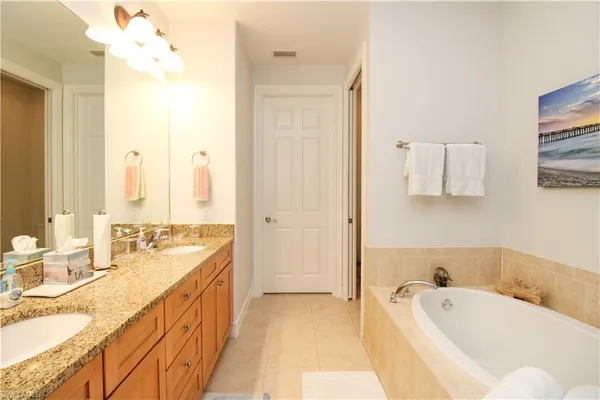 a spacious bathroom with a tub sink and mirror