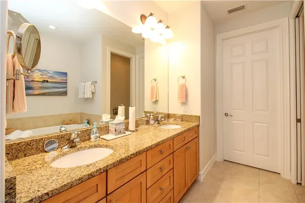 a spacious bathroom with a double vanity sink and a mirror