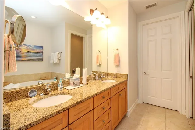 a spacious bathroom with a double vanity sink and a mirror