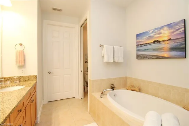 a bathroom with a tub a sink and a window