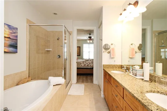 a spacious bathroom with a tub sink shower and mirror
