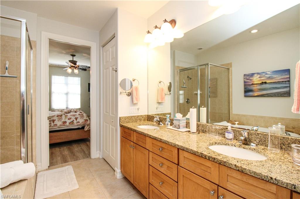 9159 Delano Street, Unit 9905 Naples, FL 34113 - Photo 37 of 44 a en suite bathroom with double sink and a mirror