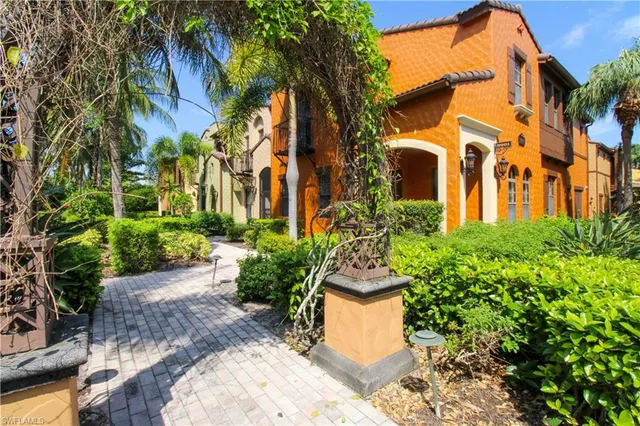 a view of a multi story residential apartment building with a yard