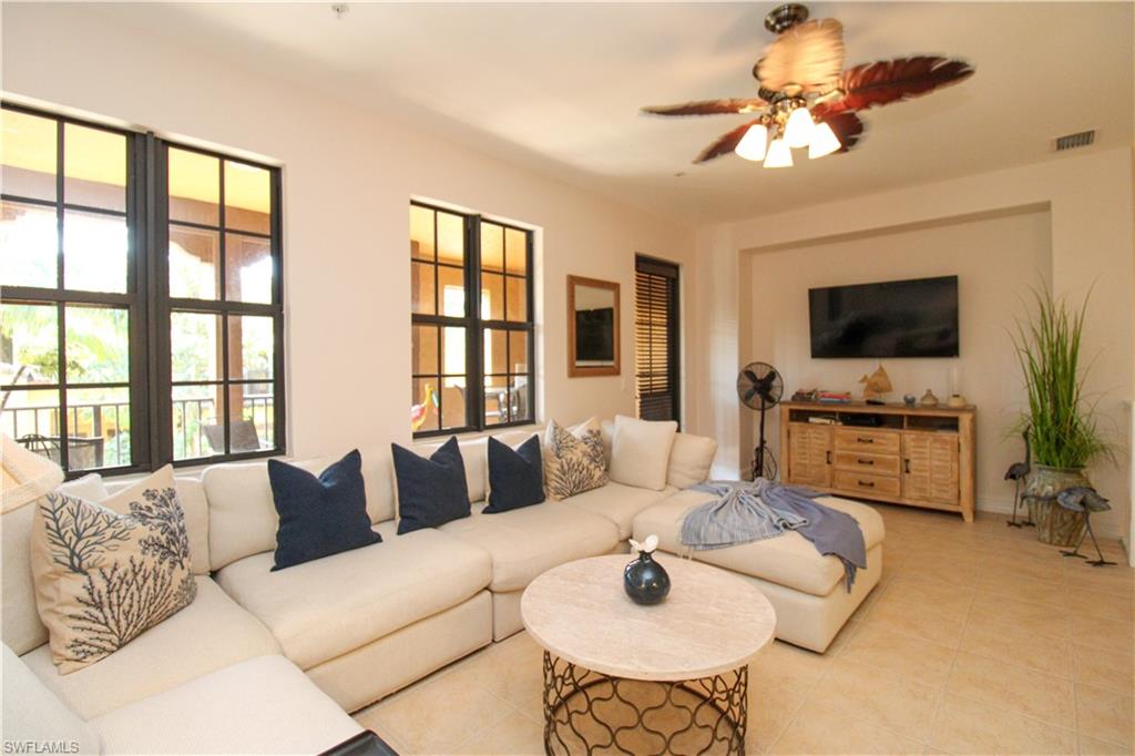 9159 Delano Street, Unit 9905 Naples, FL 34113 - Photo 10 of 44 a living room with furniture and a flat screen tv
