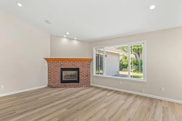 an empty room with windows and fireplace