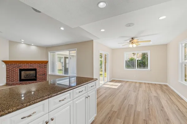 a kitchen with granite countertop a stove a sink and a wooden floors
