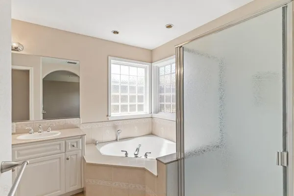 a bathroom with a tub a sink and a window