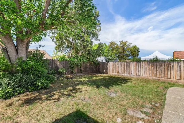a view of a backyard with wooden fence