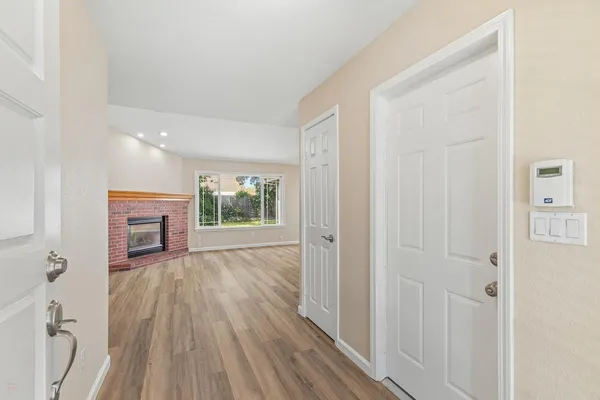 a view of a livingroom with wooden floor a fireplace and window