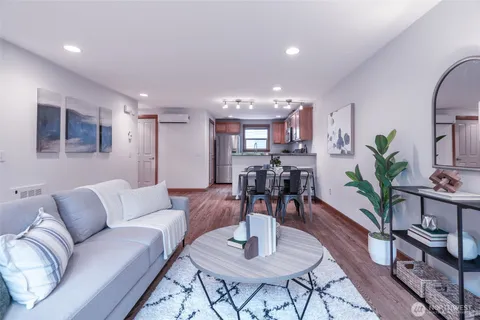 a living room with furniture and a dining table with wooden floor