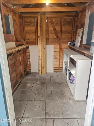 a view of an empty room with wooden floor and windows