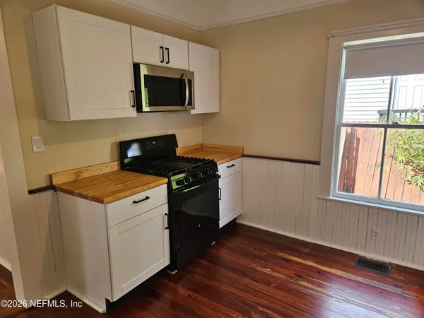 a kitchen with granite countertop a stove and a wooden floor