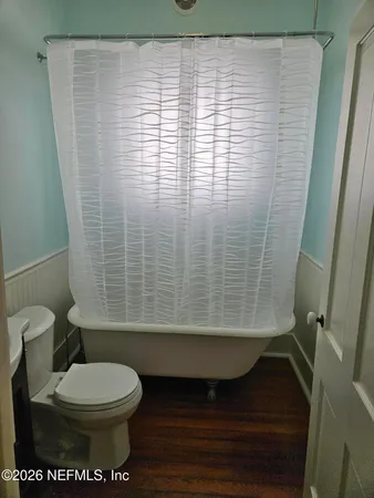 a bathroom with a toilet and a shower curtain