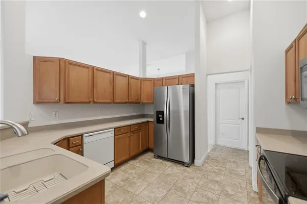 a kitchen with stainless steel appliances granite countertop a refrigerator and a sink