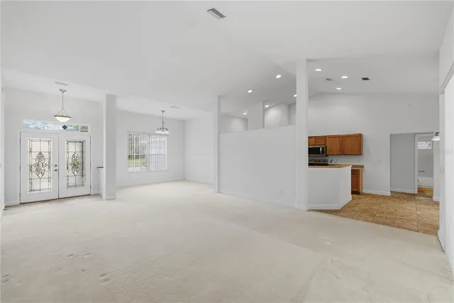 an empty room with kitchen and windows