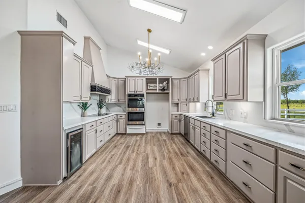 a large kitchen with cabinets wooden floor and stainless steel appliances