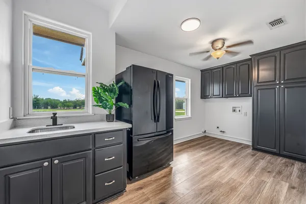 a kitchen with a refrigerator sink and cabinets