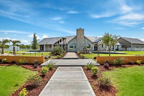 a view of swimming pool with lawn chairs and plants