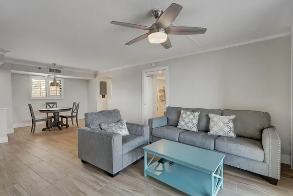 a living room with furniture and a ceiling fan