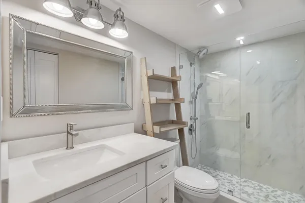 a bathroom with a sink a toilet and shower